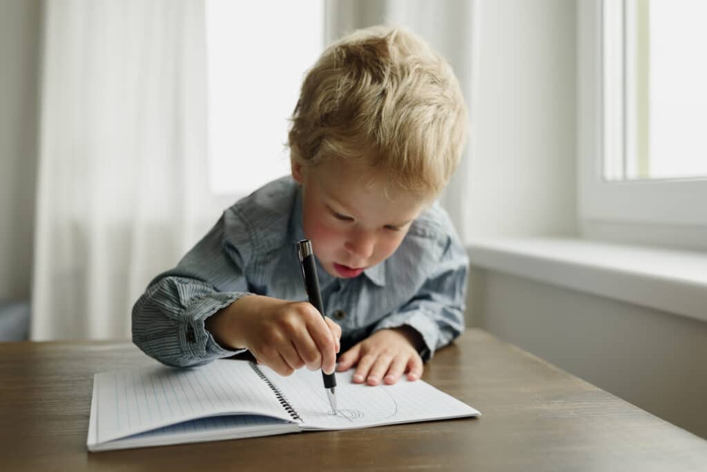 Enfant en train d'écrire sur une feuille