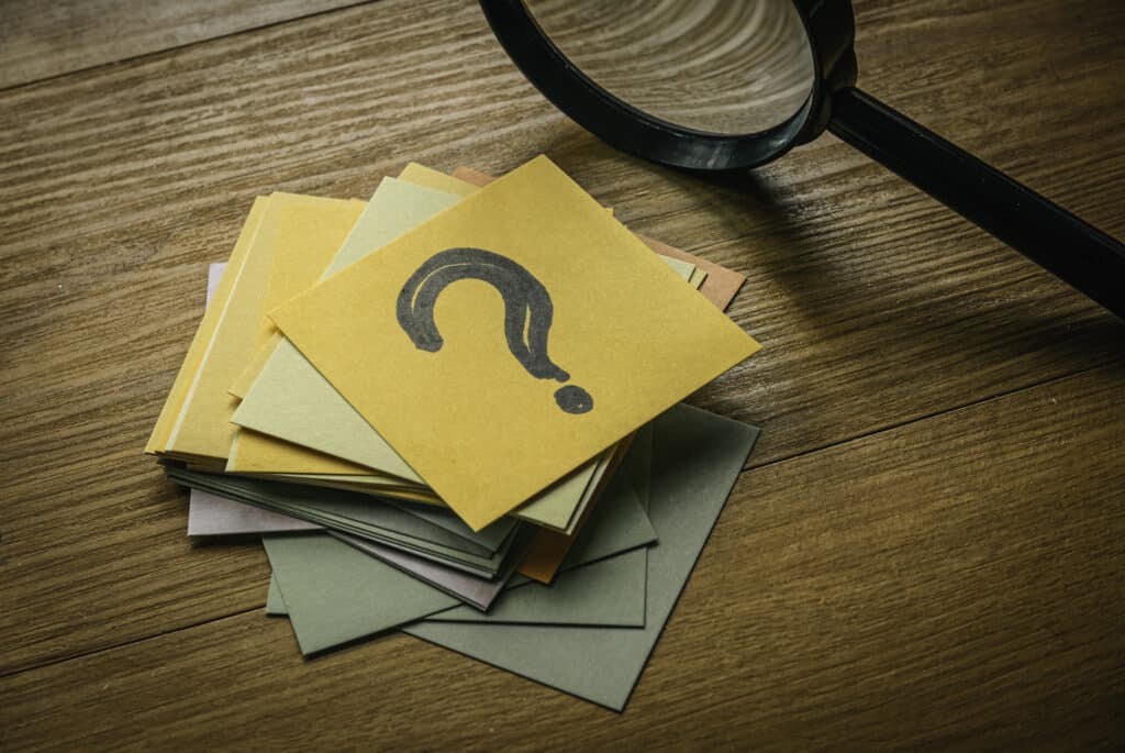 Concept de questions et réponses. Une pile de papier avec un papier sur le dessus écrit avec le symbole de la question.